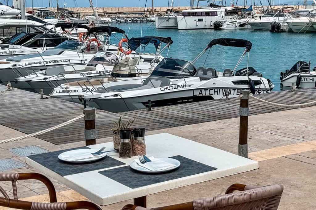 Restaurant table at Latchi harbour with boats in the background